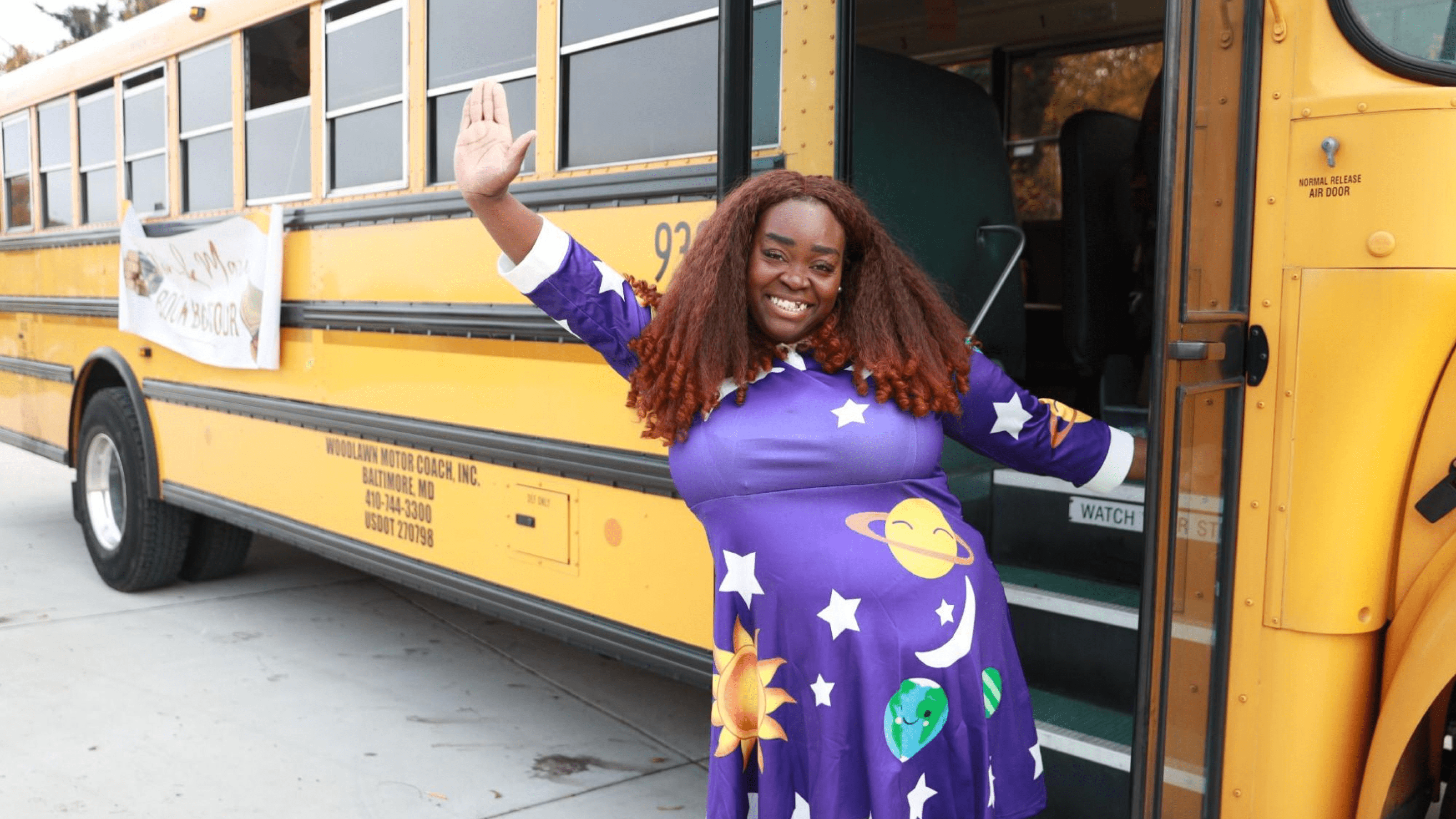 Event creator stands outside of a school bus waving