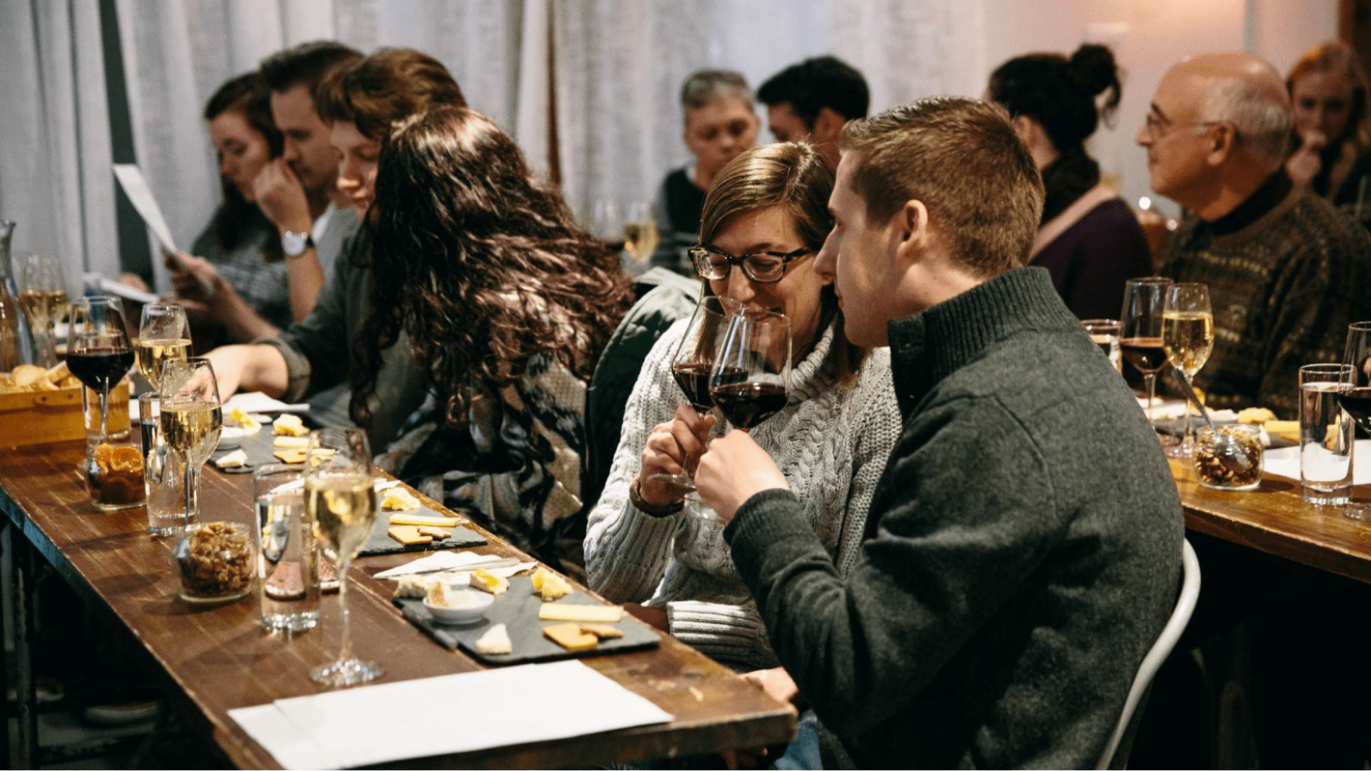 Couple tasting cheese and wine at event